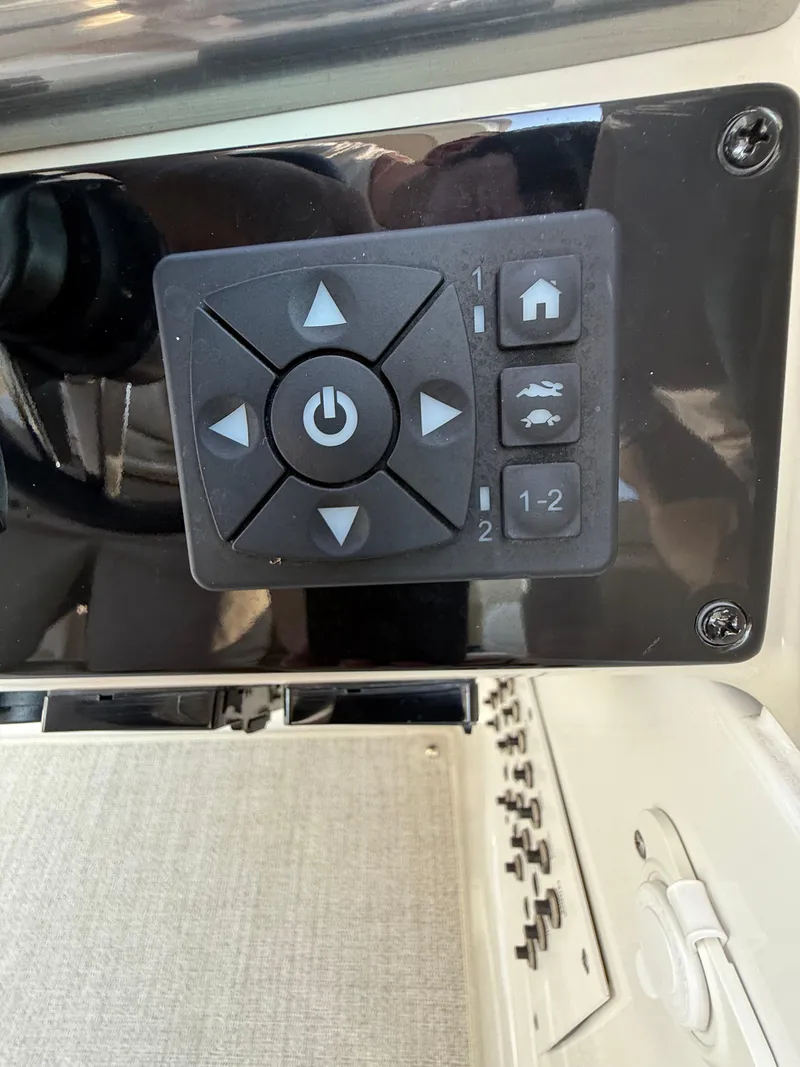 Slide: The Image of Control panel of 2024 Formula 350 Crossover Bowrider with directional buttons and power symbol. - 55