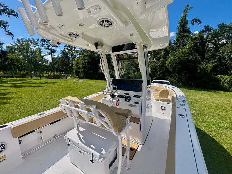Slide: The Image of 2024 Sportsman Open 232 Center Console boat on grassy area, showcasing helm and seating. - 2