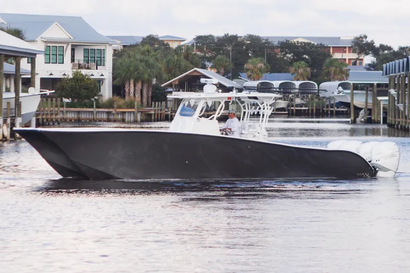 The Image of 2021 Tag 360 Catamaran cruising in a marina with modern buildings in the background. - 0