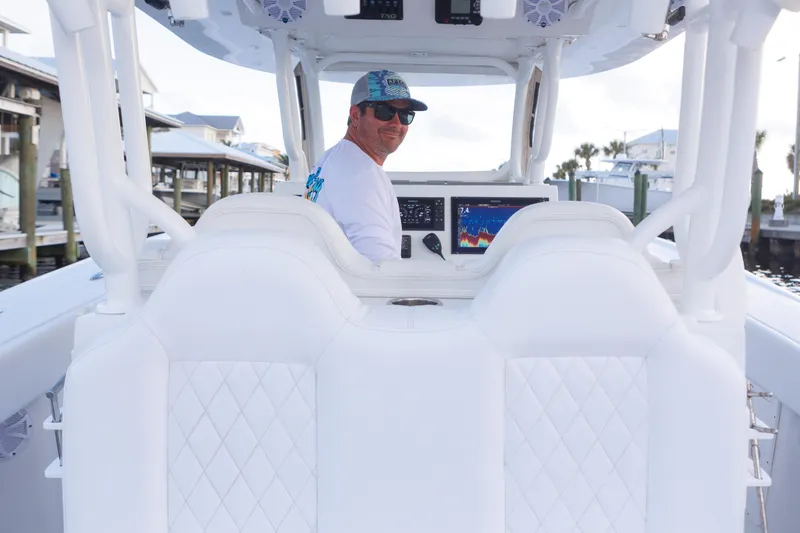 Slide: The Image of Man steering 2021 Tag 360 Catamaran, wearing sunglasses and cap, with navigation display visible. - 16