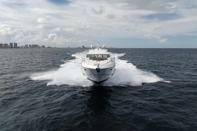 Slide: The Image of Sunseeker 74 Sport Yacht 2012 cruising on open water, city skyline in background. - 1