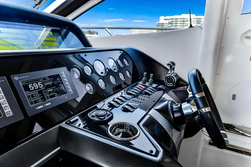Slide: The Image of Control panel of a 2012 Sunseeker 74 Sport Yacht with steering wheel and digital displays. - 13