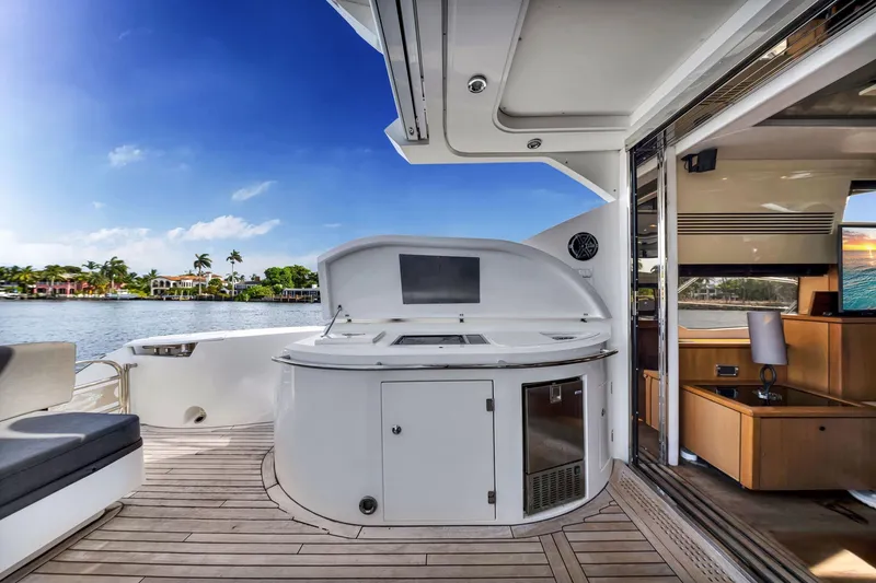 Slide: The Image of Luxurious Sunseeker 74 Sport Yacht deck with outdoor kitchen, overlooking serene waterfront. - 14