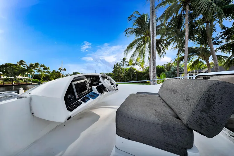 Slide: The Image of Helm of 2012 Sunseeker 74 Sport Yacht with palm trees and blue sky backdrop. - 48