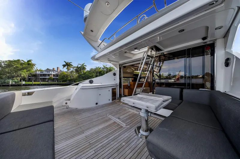 Slide: The Image of Luxurious 2012 Sunseeker 74 Sport Yacht deck with seating, table, and scenic waterfront view. - 8