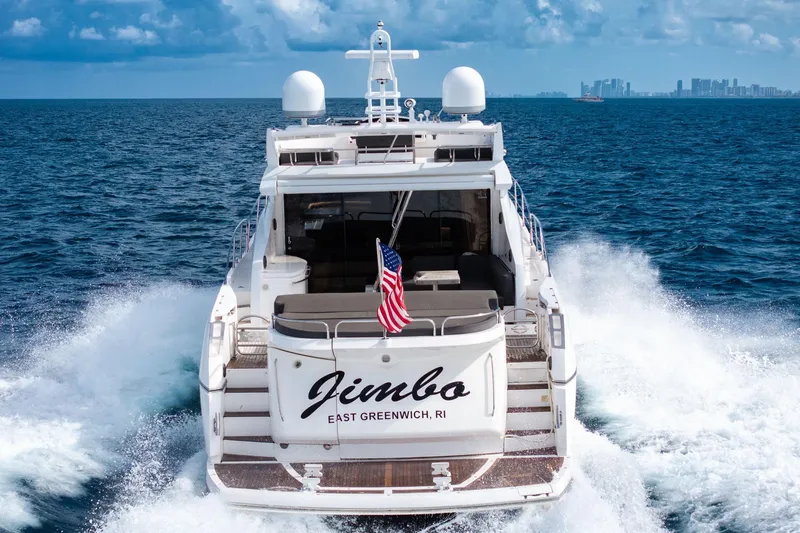 Slide: The Image of Sunseeker 74 Sport Yacht 2012 cruising with American flag, ocean backdrop. - 9