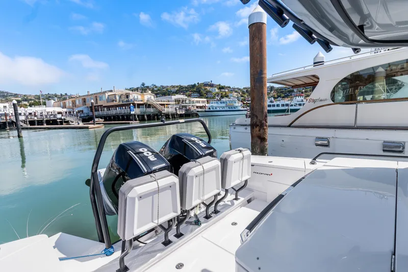 Slide: The Image of 2021 Axopar 37 XC BRABUS Trim Wet Bar with dual outboard motors docked in a marina. - 11