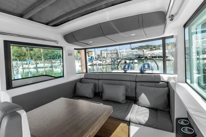 Slide: The Image of Interior of 2021 Axopar 37 XC BRABUS Trim Wet Bar, featuring sleek seating and marina view. - 22