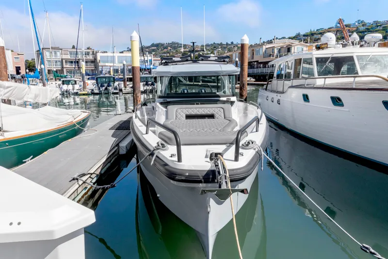 Slide: The Image of 2021 Axopar 37 XC BRABUS Trim Wet Bar docked in a marina. - 3