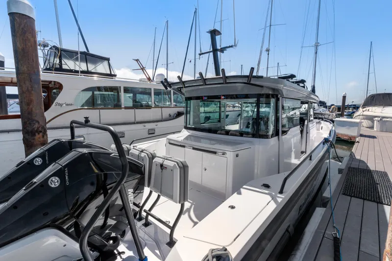 Slide: The Image of 2021 Axopar 37 XC BRABUS Trim Wet Bar docked at marina, showcasing sleek design and powerful engines. - 5