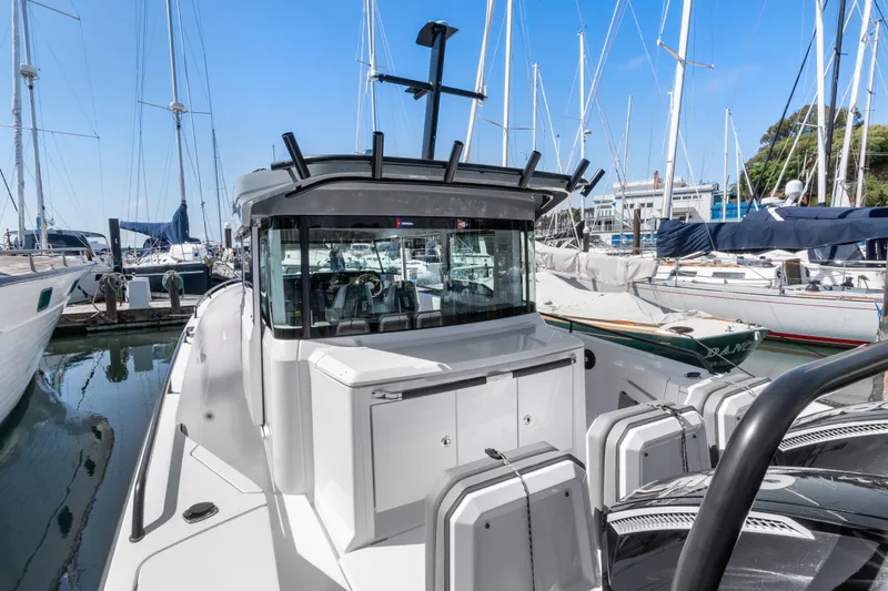 Slide: The Image of 2021 Axopar 37 XC BRABUS Trim Wet Bar docked among sailboats. - 6