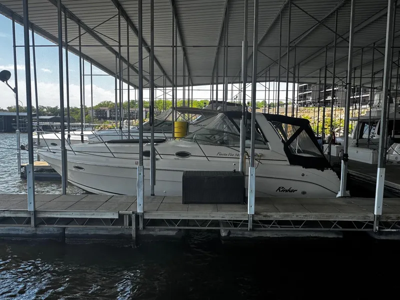 The Image of 2000 Rinker 340 Fiesta Vee boat docked in a covered marina. - 0