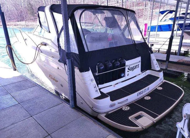 Slide: The Image of 2000 Rinker 340 Fiesta Vee boat docked, featuring a covered cockpit and spacious swim platform. - 11