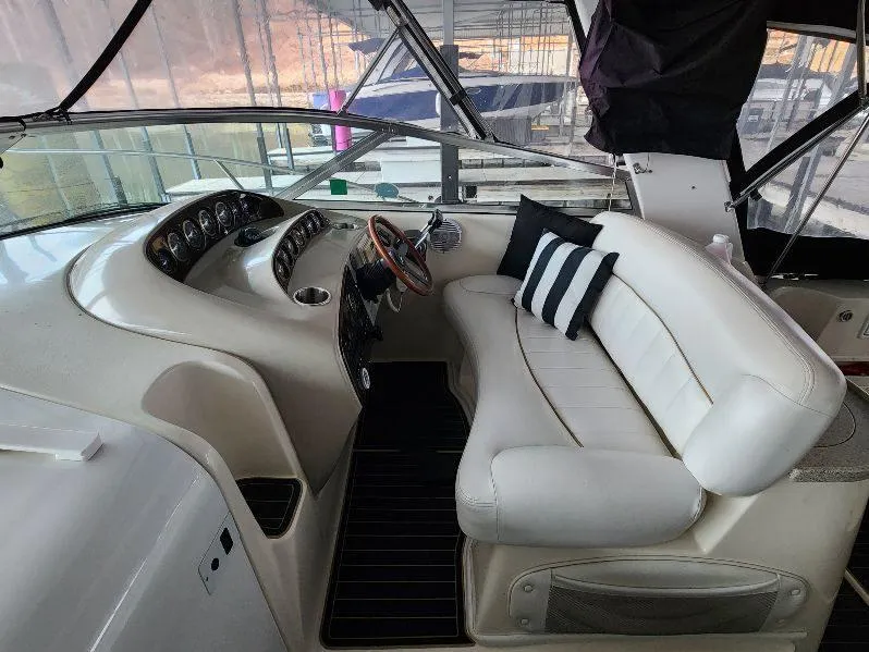 Slide: The Image of Interior of 2000 Rinker 340 Fiesta Vee boat with white seating and striped pillows. - 17