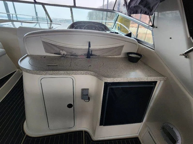 Slide: The Image of 2000 Rinker 340 Fiesta Vee boat interior with kitchenette and compact fridge. - 19