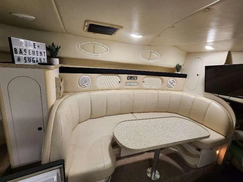 Slide: The Image of Interior of 2000 Rinker 340 Fiesta Vee boat with beige seating and table. - 29