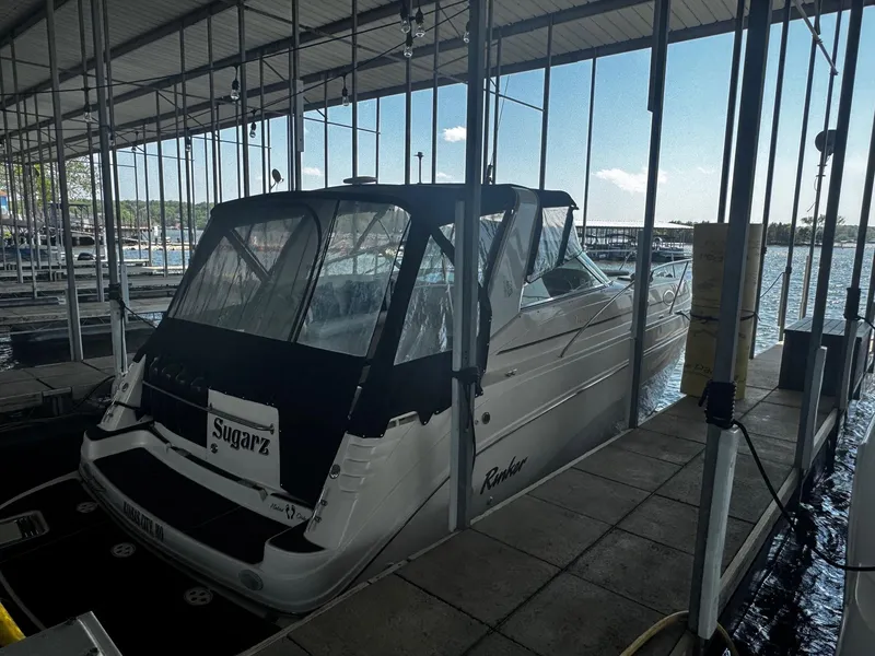 Slide: The Image of 2000 Rinker 340 Fiesta Vee boat docked in a marina under a covered shelter. - 3