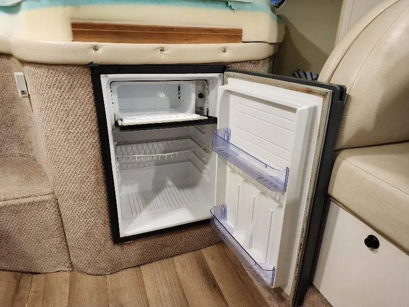 Slide: The Image of Open mini fridge inside 2000 Rinker 340 Fiesta Vee boat cabin. - 32