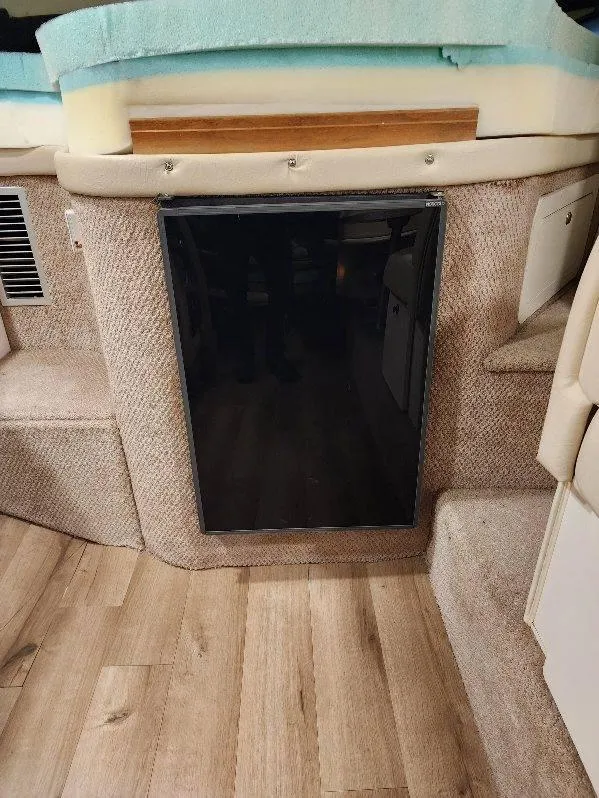 Slide: The Image of Interior of 2000 Rinker 340 Fiesta Vee boat, featuring a compact refrigerator. - 34