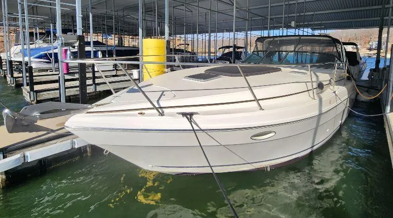 Slide: The Image of 2000 Rinker 340 Fiesta Vee boat docked in a marina under a covered shelter. - 6