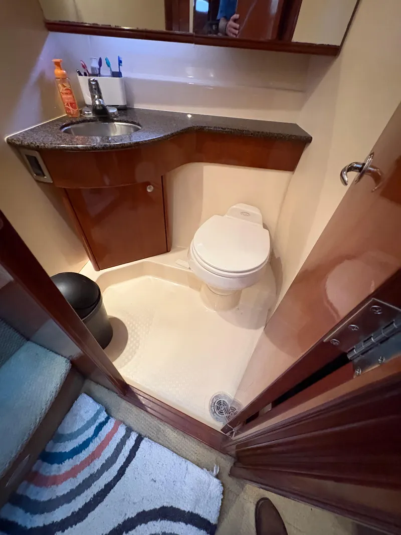 Slide: The Image of Compact bathroom in 2006 Meridian Fly Bridge Convertible yacht with sink, toilet, and mirror. - 19