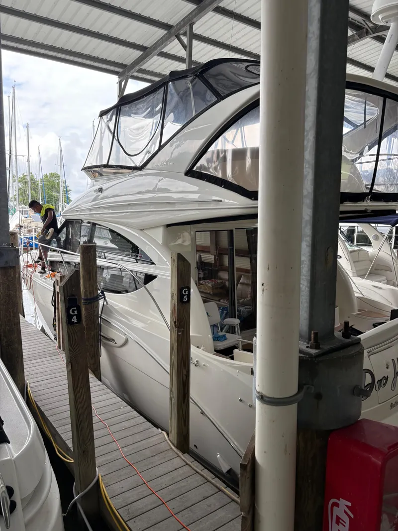 The Image of 2006 Meridian Fly Bridge Convertible docked in a marina under a covered shelter. - 1