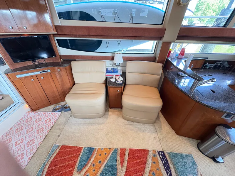 Slide: The Image of Interior of 2006 Meridian Fly Bridge Convertible with beige chairs and wooden cabinetry. - 16