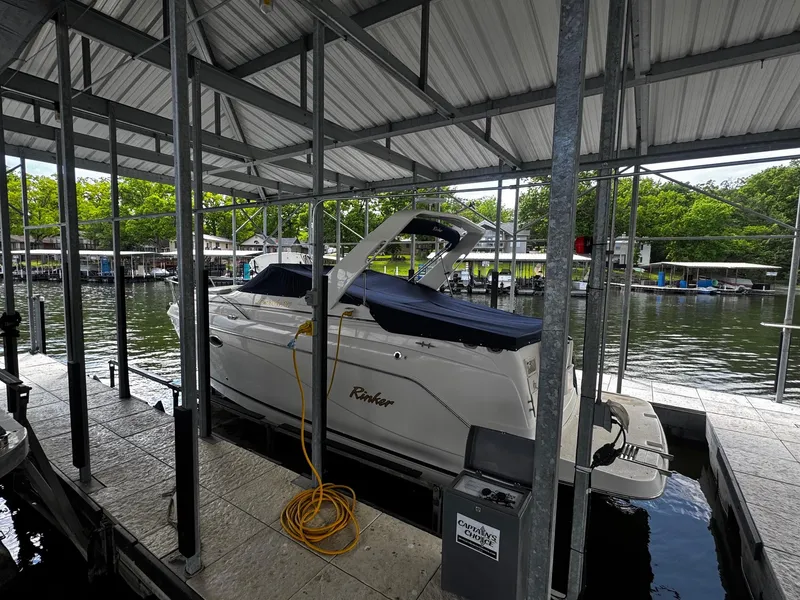 Slide: The Image of 2003 Rinker 270 Express Cruiser docked under a covered marina. - 11