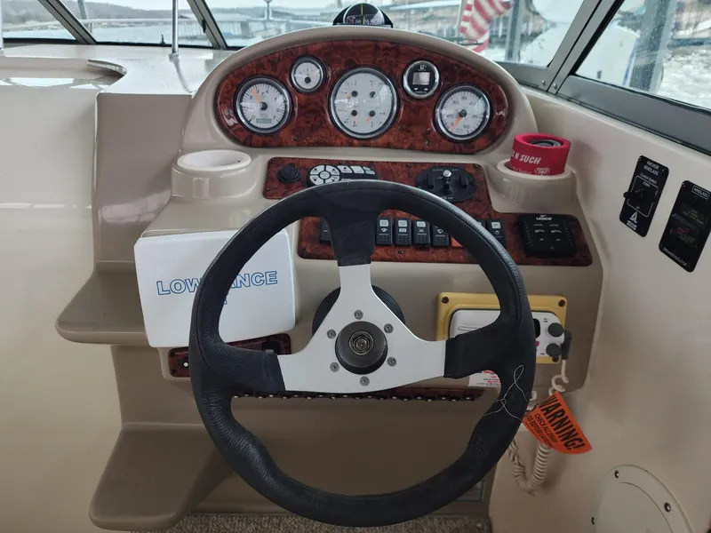 Slide: The Image of 2003 Rinker 270 Express Cruiser dashboard with steering wheel and navigation instruments. - 14