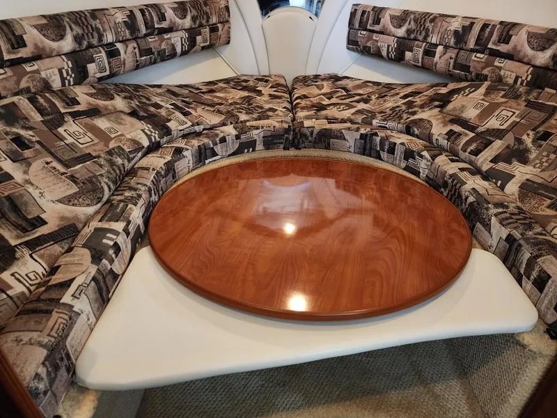 Slide: The Image of 2003 Rinker 270 Express Cruiser interior with patterned seating and wooden table. - 25