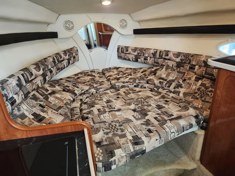 Slide: The Image of Interior of 2003 Rinker 270 Express Cruiser with patterned seating and wood accents. - 26