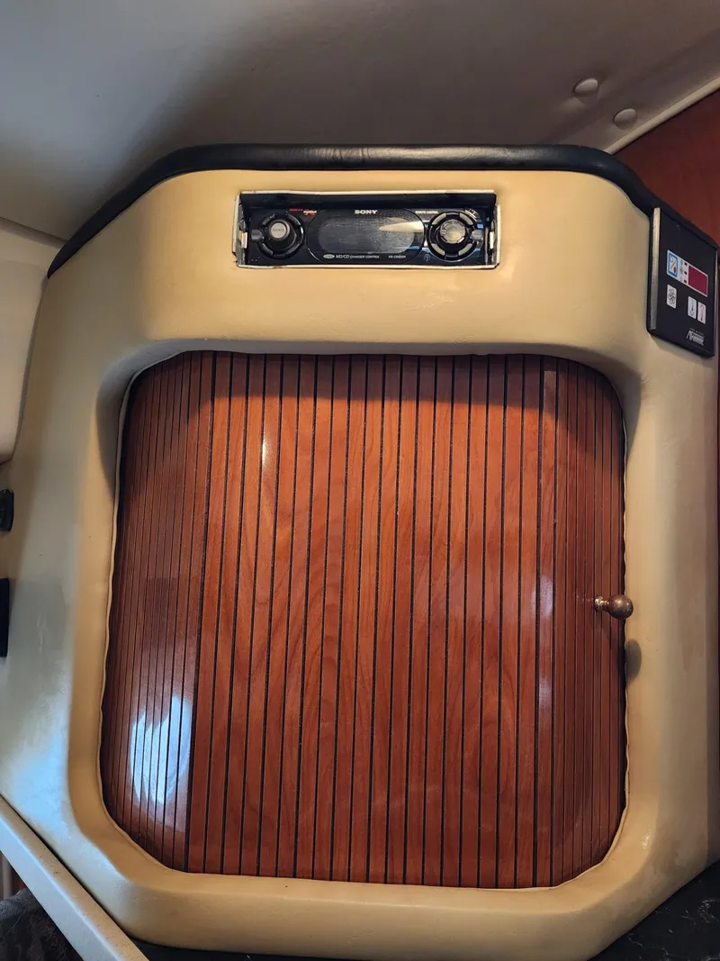 Slide: The Image of 2003 Rinker 270 Express Cruiser interior with wood paneling and audio system. - 29