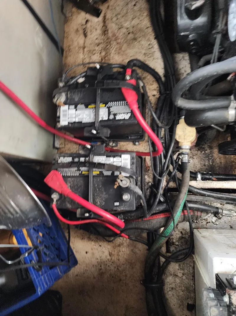 Slide: The Image of Batteries and wiring in a 2003 Rinker 270 Express Cruiser engine compartment. - 39