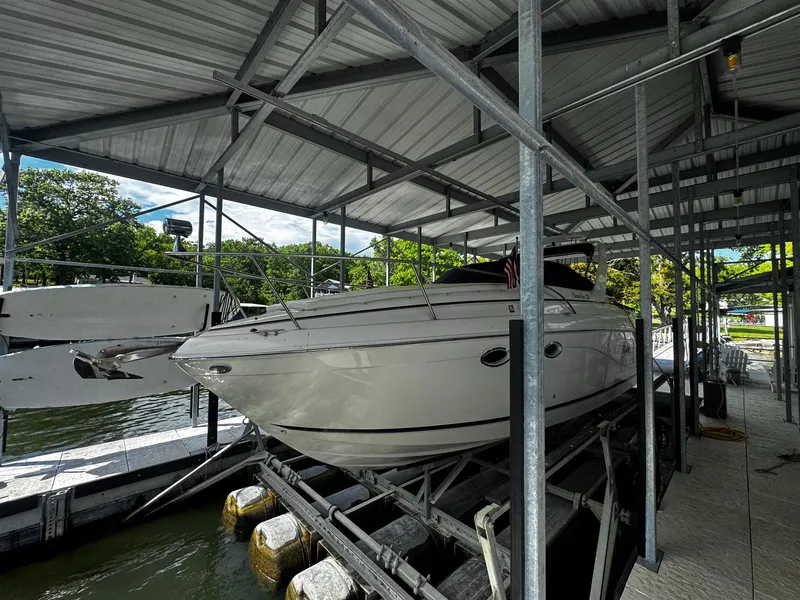 Slide: The Image of 2003 Rinker 270 Express Cruiser docked under a metal canopy. - 8