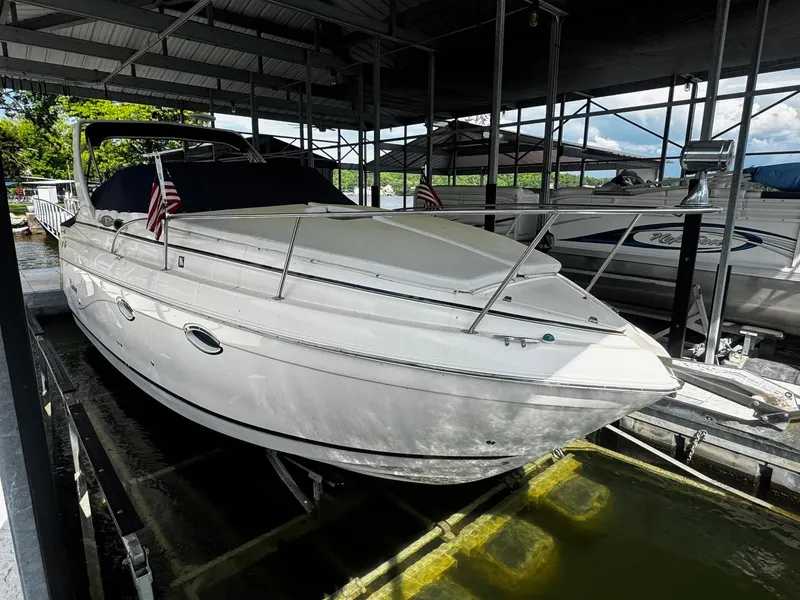 Slide: The Image of 2003 Rinker 270 Express Cruiser docked in a covered marina. - 9