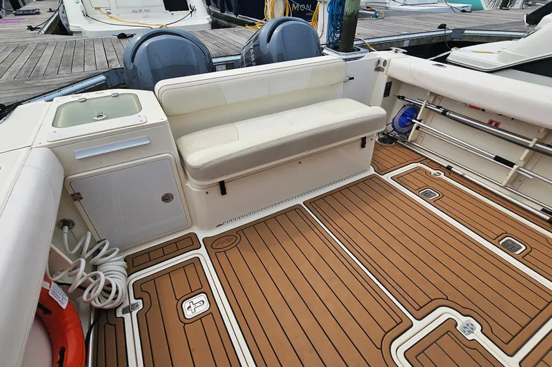 Slide: The Image of 2009 Pursuit OS 315 Offshore boat interior with cushioned seating and teak flooring. - 11
