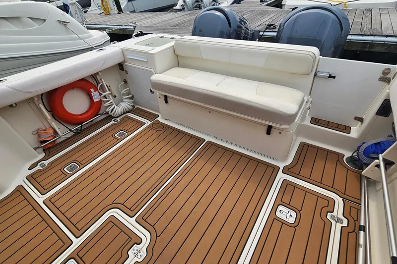 Slide: The Image of 2009 Pursuit OS 315 Offshore boat interior with cushioned seating and teak-style flooring. - 12