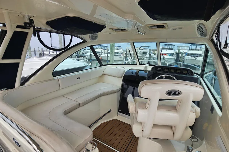 Slide: The Image of 2009 Pursuit OS 315 Offshore boat interior with helm, seating, and marina view. - 15