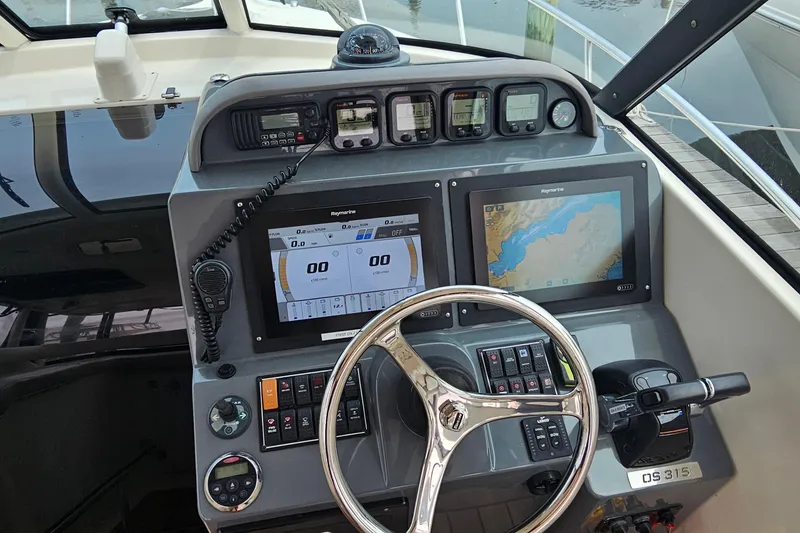 Slide: The Image of 2009 Pursuit OS 315 Offshore boat dashboard with navigation screens and controls. - 18