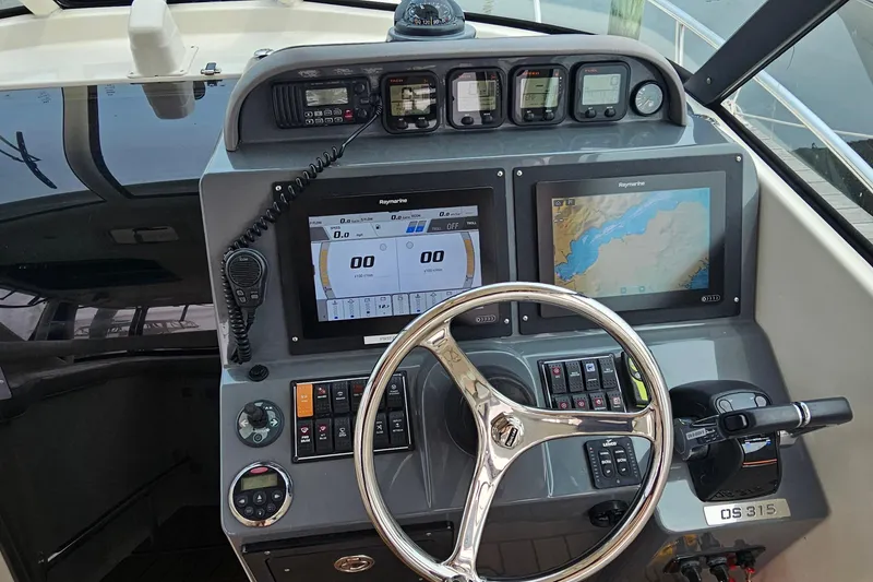 Slide: The Image of 2009 Pursuit OS 315 Offshore boat dashboard with navigation screens and controls. - 19