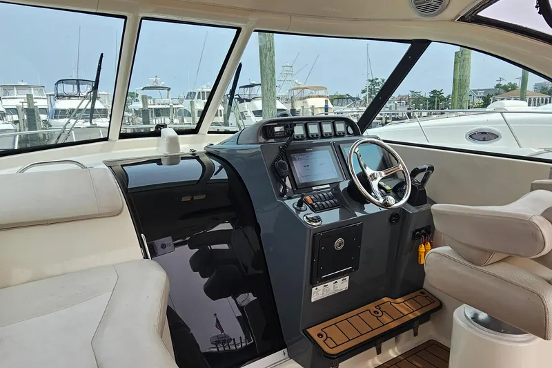 Slide: The Image of 2009 Pursuit OS 315 Offshore boat cockpit with steering wheel and navigation controls. - 20