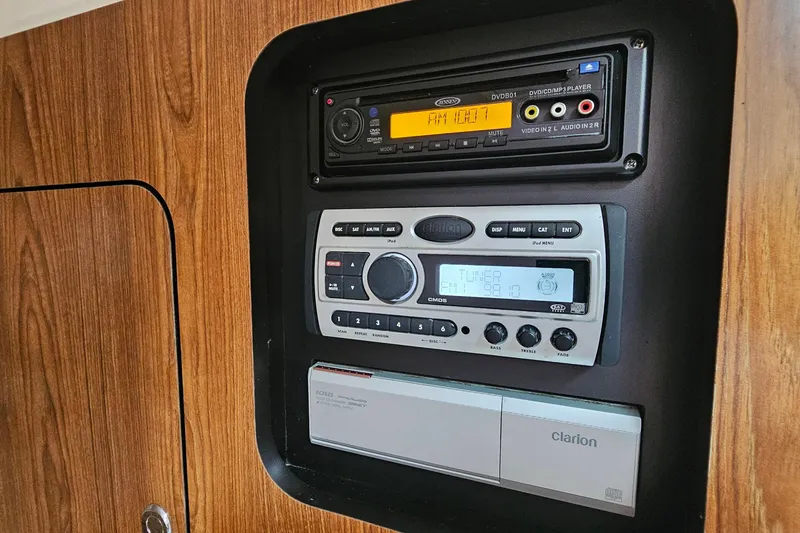 Slide: The Image of 2009 Pursuit OS 315 Offshore cabin audio system with Clarion controls and wood paneling. - 25