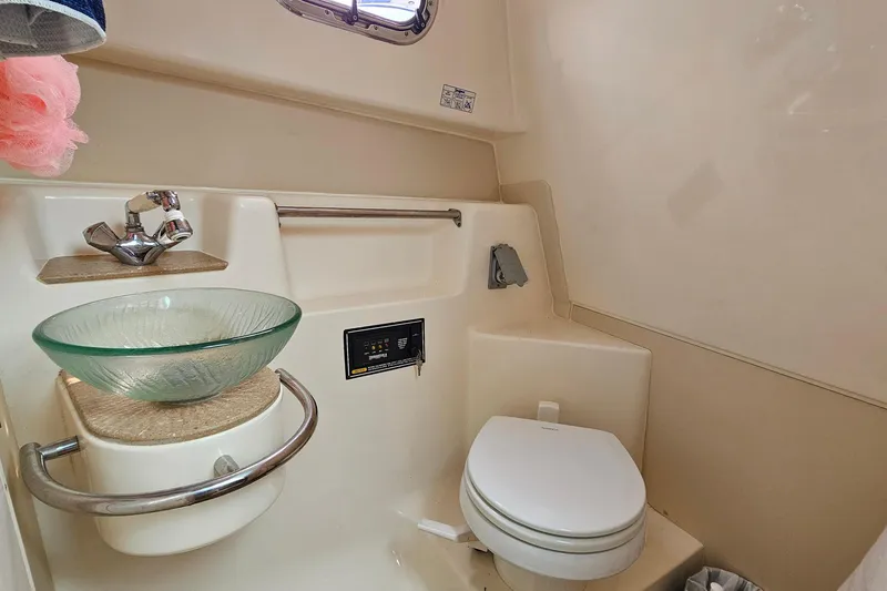 Slide: The Image of 2009 Pursuit OS 315 Offshore boat bathroom with glass sink and compact toilet. - 26
