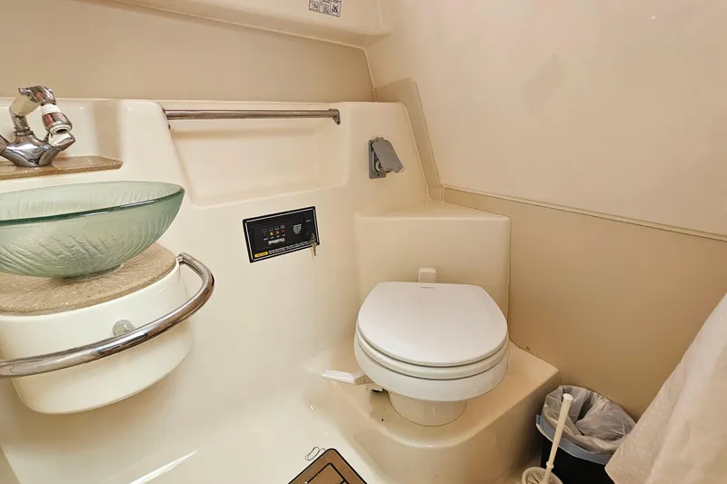 Slide: The Image of 2009 Pursuit OS 315 Offshore boat bathroom with glass sink and toilet. - 27