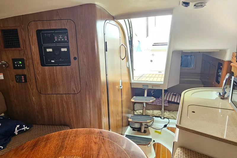Slide: The Image of 2009 Pursuit OS 315 Offshore cabin interior with wood paneling and compact kitchen area. - 29