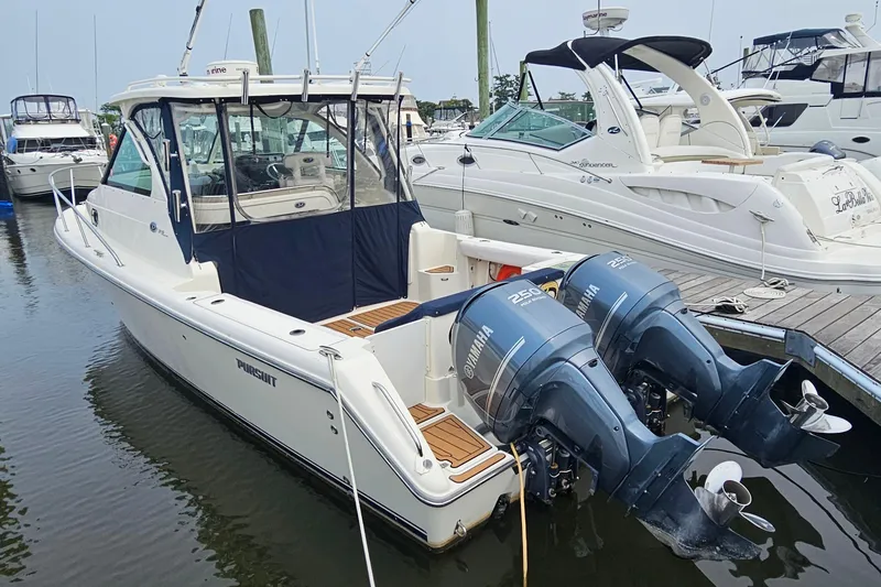 Slide: The Image of 2009 Pursuit OS 315 Offshore boat docked with twin Yamaha engines. - 3