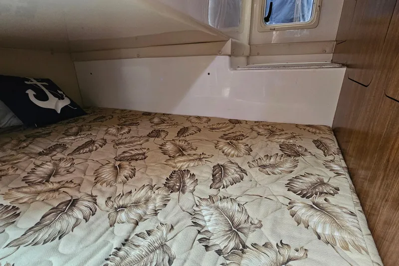 Slide: The Image of 2009 Pursuit OS 315 Offshore cabin with leaf-patterned bedding and anchor pillow. - 30