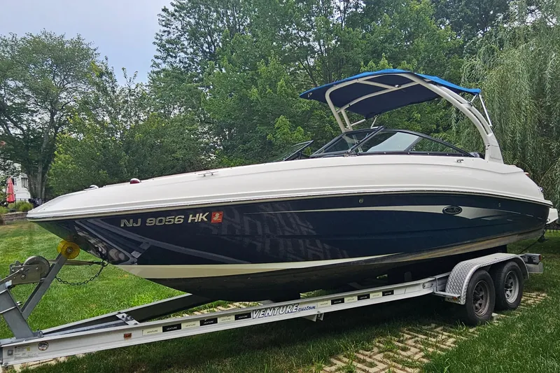 Slide: The Image of 2017 Sea Ray SDX 240 Outboard boat on trailer, parked on grass. - 17