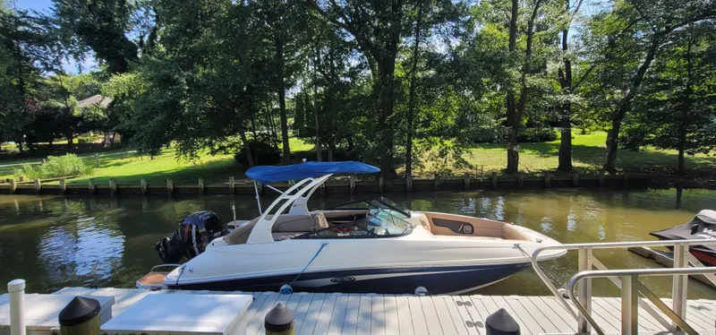 Slide: The Image of 2017 Sea Ray SDX 240 Outboard boat docked by a scenic, tree-lined canal. - 2