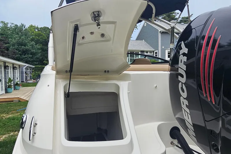 Slide: The Image of 2017 Sea Ray SDX 240 Outboard with open storage compartment and Mercury engine. - 22